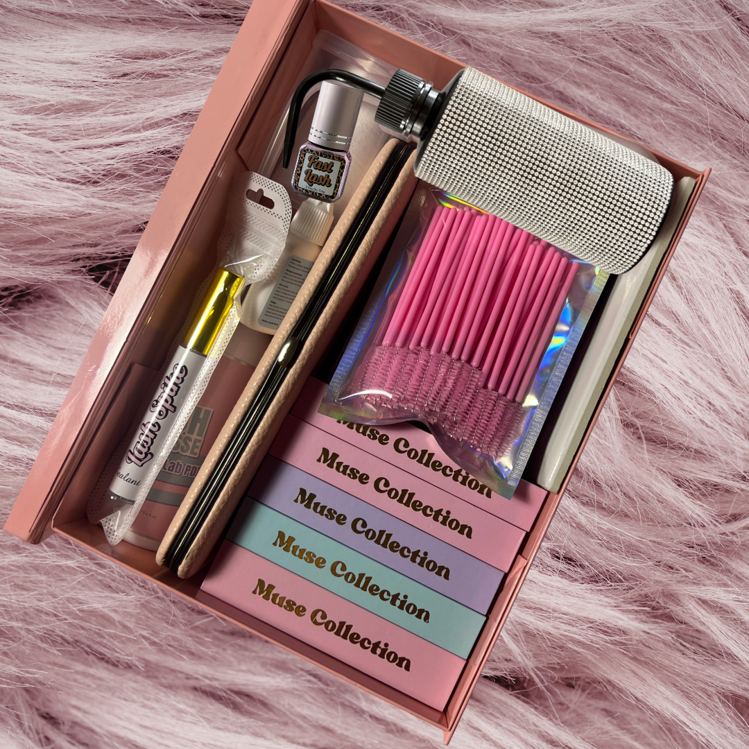 lash training kit, includes lash trays, spike gel, lash adhesive, tweezers, water rinse bottle, mousse lash cleanser in a pink box. The pink box is sitting on pink faux fur.