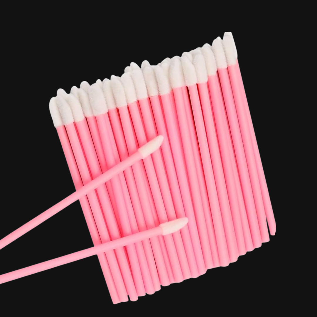 Pink cotton lip wands with white tips on a black background, used for cleansing lash extensions
