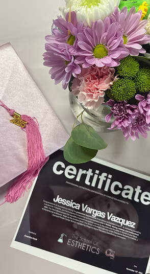 Esthetic Student certificates next to flowers.